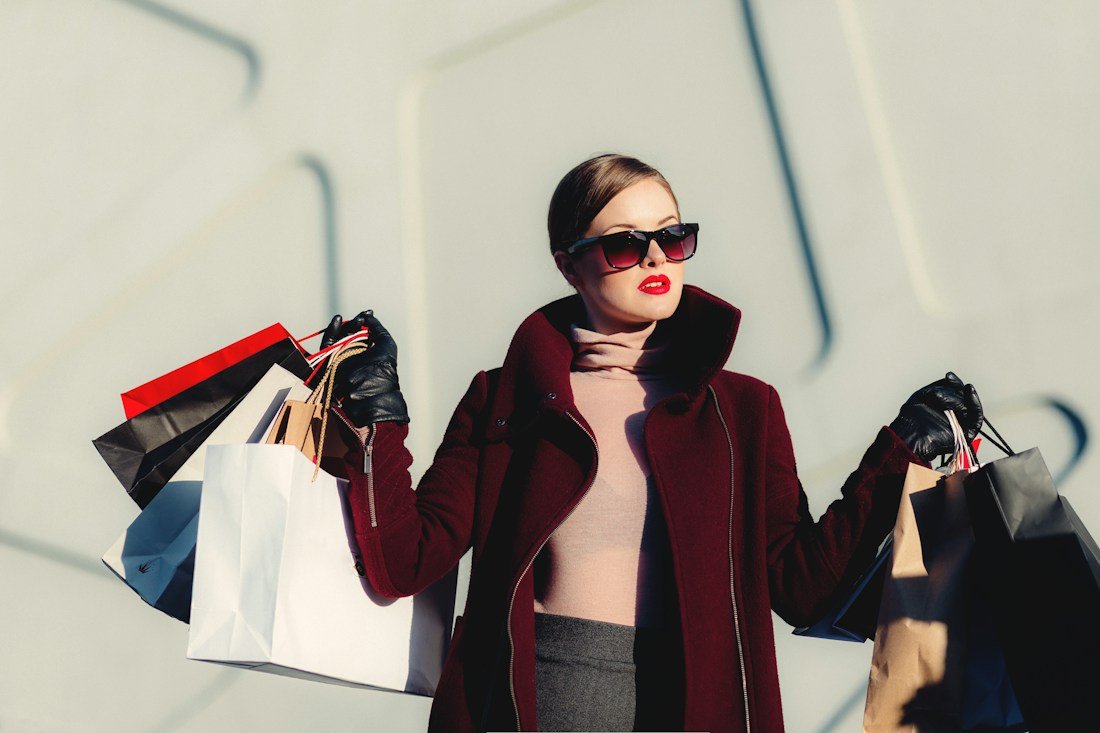 A fashion stylist carrying shopping bags.